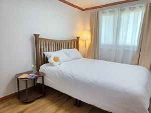a bedroom with a white bed and a window at Wizday Stay in Suwon