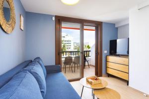 a living room with a blue couch and a television at Ocean Mark Holiday Parque Santiago 2 in Playa de las Americas