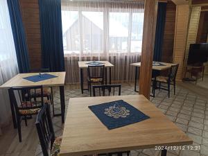 a dining room with tables and chairs and windows at Садиба Буквиця in Migovo