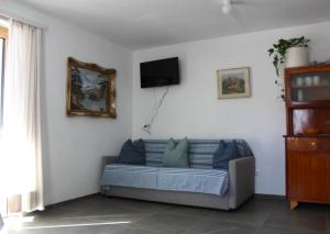 a living room with a couch and a tv on the wall at Panorama Latemar in Nova Levante