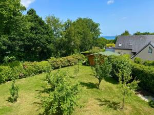 an image of a garden with trees and a house at Nid douillet Les Mouettes in Fouesnant