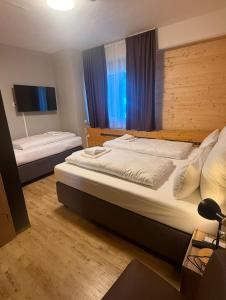a hotel room with two beds and a tv at URBAN OAK Smart Stay in Cologne