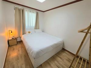 a bedroom with a white bed and a window at Wizday Stay in Suwon