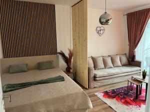 a living room with a bed and a couch at Focsani Studio Residence 3 in Focşani
