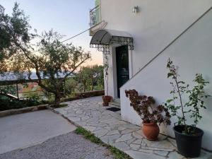 a white building with a door and some potted plants at Relax and enjoy in Raches