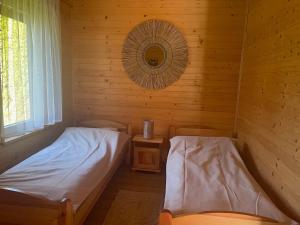 a room with two beds in a wooden cabin at Domki Alex in Dębki