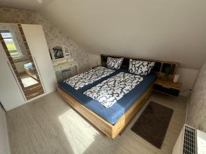 a bedroom with a large bed and a mirror at Rosenhaus Esens - Wohnung Backbord in Esens