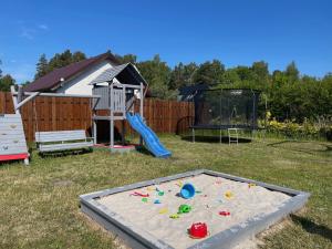 a sandbox in a yard with a play set at Domki Alex in Dębki