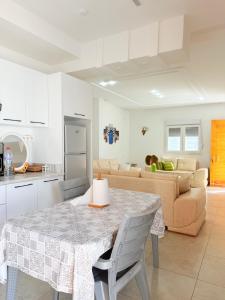 a kitchen and living room with a table and a couch at Résidence Azur Djerba in Taguermess