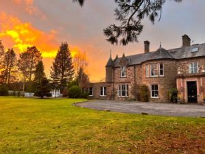 an old house with a sunset in the background at McArthur Manor in Blairgowrie