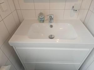 a white bathroom sink with a bottle of soap on it at Moderne Ferienwohnung "Adriane" mit gehobener Ausstattung - Top bewertet in Nordhorn +15 photos