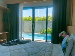 a bedroom with a bed and a view of a pool at Aonang Homie Pool villa in Ao Nang 