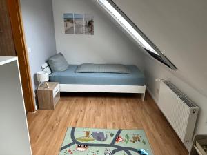 a small bedroom with a bed in a stair room at Rosenhaus Esens - Wohnung Backbord in Esens +17 photos