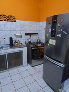 a kitchen with a stainless steel refrigerator and a stove at Apartamentos e Casas em Barra do Cunhaú in Canguaretama