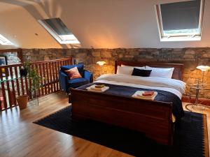 a bedroom with a large bed and a stone wall at Woodville Barn in Ród