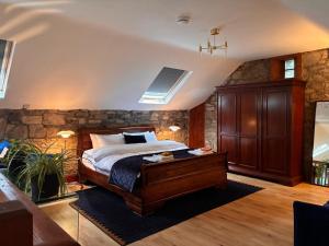 a bedroom with a bed and a stone wall at Woodville Barn in Ród