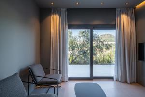 a living room with two chairs and a large window at The Alma Suite in Alora