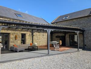 a patio with a couch and a table in front of a building at Woodville Barn in Ród