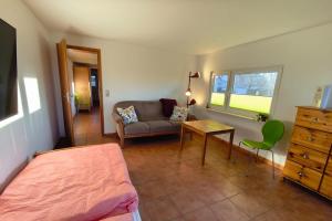 a bedroom with a bed and a couch and a table at A short break on Germany's largest island in Garz