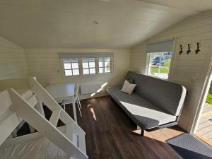 a tiny house with a couch and a table at Trellebystrands Camping in Lysekil