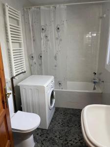 a bathroom with a tub and a washing machine in it at Large and cozy studio in Piera +15 photos