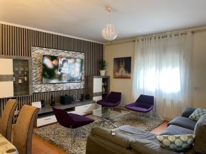 a living room with a couch and purple chairs at Large and cozy studio in Piera