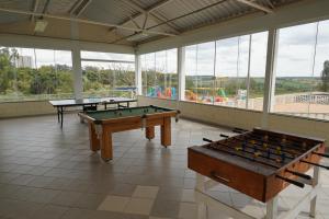 two ping pong tables in a large room with windows at Eventos e Hospedagem São José in Sorocaba