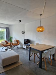 a living room with a table and chairs at Appartement op topligging! in Cadzand
