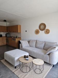 a living room with a couch and two tables at Appartement op topligging! in Cadzand