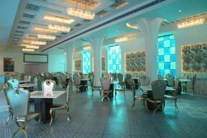 a dining room with tables and chairs and windows at Ascent Eco Resorts & Conventions in Rājānagaram