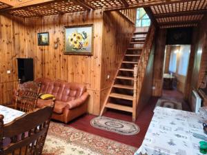 a living room with a spiral staircase in a house at Калина in Deneshi