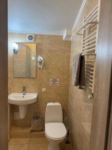 ein kleines Badezimmer mit Toilette und Waschbecken in der Unterkunft Каприз in Kamjanez-Podilskyj + 180 Fotos