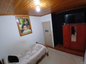 a small bedroom with a bed and a tv in it at Dario Claussen house in Garupá
