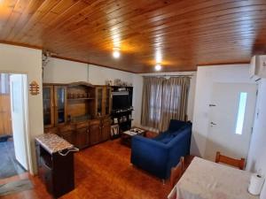 a living room with a blue couch and wooden ceiling at Dario Claussen house in Garupá