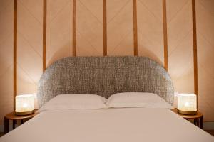 a bedroom with a bed with two lamps on either side at Palazzo Gulino in Palma di Montechiaro