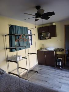 a living room with a ceiling fan and a kitchen at Contenedor el Colibrí in Naranjo