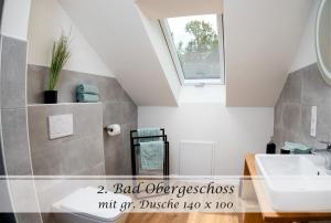a bathroom with a sink and a mirror at Ferienwohnung Frieda - Gulfhof nahe Greetsiel mit Sauna, Garten & 3 Schlafzimmern in Krummhörn +18 photos