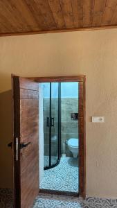 a bathroom with a toilet and a glass door at Pergamon Yunt Evleri in Bergama