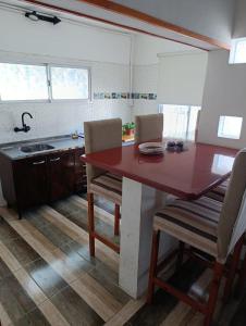 a kitchen with a red table and two chairs at La soñada 1 in Villa Mercedes