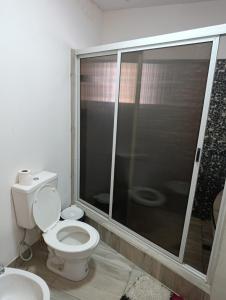 a bathroom with a toilet and a glass shower at La soñada 1 in Villa Mercedes +5 photos
