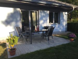 a patio with a table and chairs in front of a house at Ferienwohnung ANKER in Lubmin