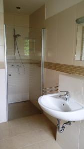 a white bathroom with a sink and a shower at Ferienwohnung ANKER in Lubmin