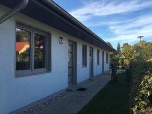 a white building with a door on the side of it at Ferienwohnung ANKER in Lubmin