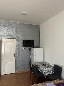 a room with a refrigerator and a table and a door at Apartman Stil in Kruševac