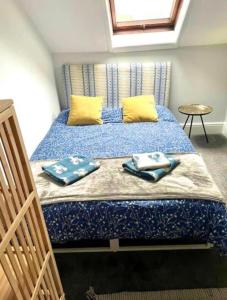 a bedroom with a bed with blue sheets and yellow pillows at Central location location in Hollington