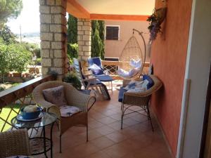 a patio with chairs and a table on a balcony at Apartment in a villa with a private pool in Cannigione