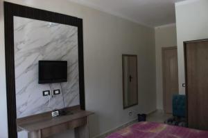 a mirror in a room with a tv on a wall at فندق النادي in Aswan