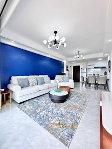 a living room with a white couch and a blue wall at Araka Homes-Westlands in Nairobi