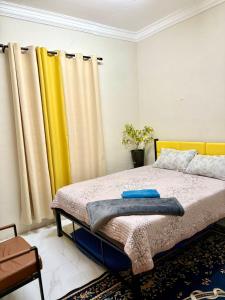 a bedroom with a bed with yellow curtains at Teratak D' Chemumaq Arau in Arau