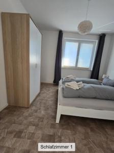 a bedroom with a bed and a large window at Ferienwohnung ANKER in Lubmin